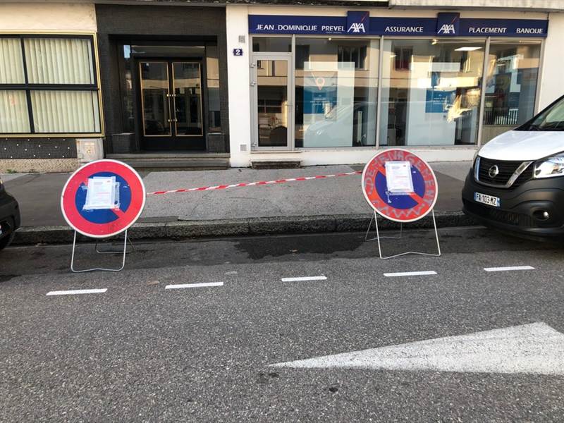 Panneaux de stationnement interdit posés devant une adresse, avec l'arrêté municipal affiché
